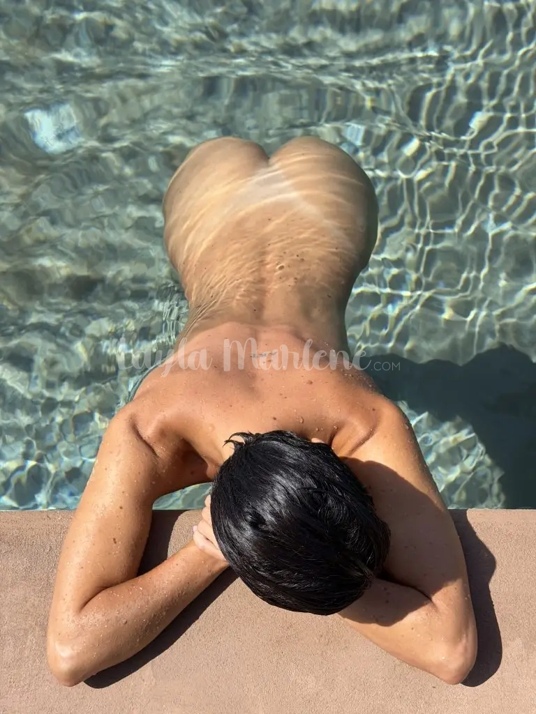 Layla nuda in piscina mostrando il suo culetto e il segno del costume
